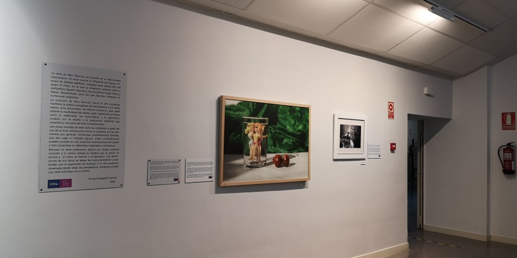Vista del pasillo con un panel de texto sobre Nino Barriuso, la fotografía del vaso, otra foto enmarcada y una puerta al fondo.
